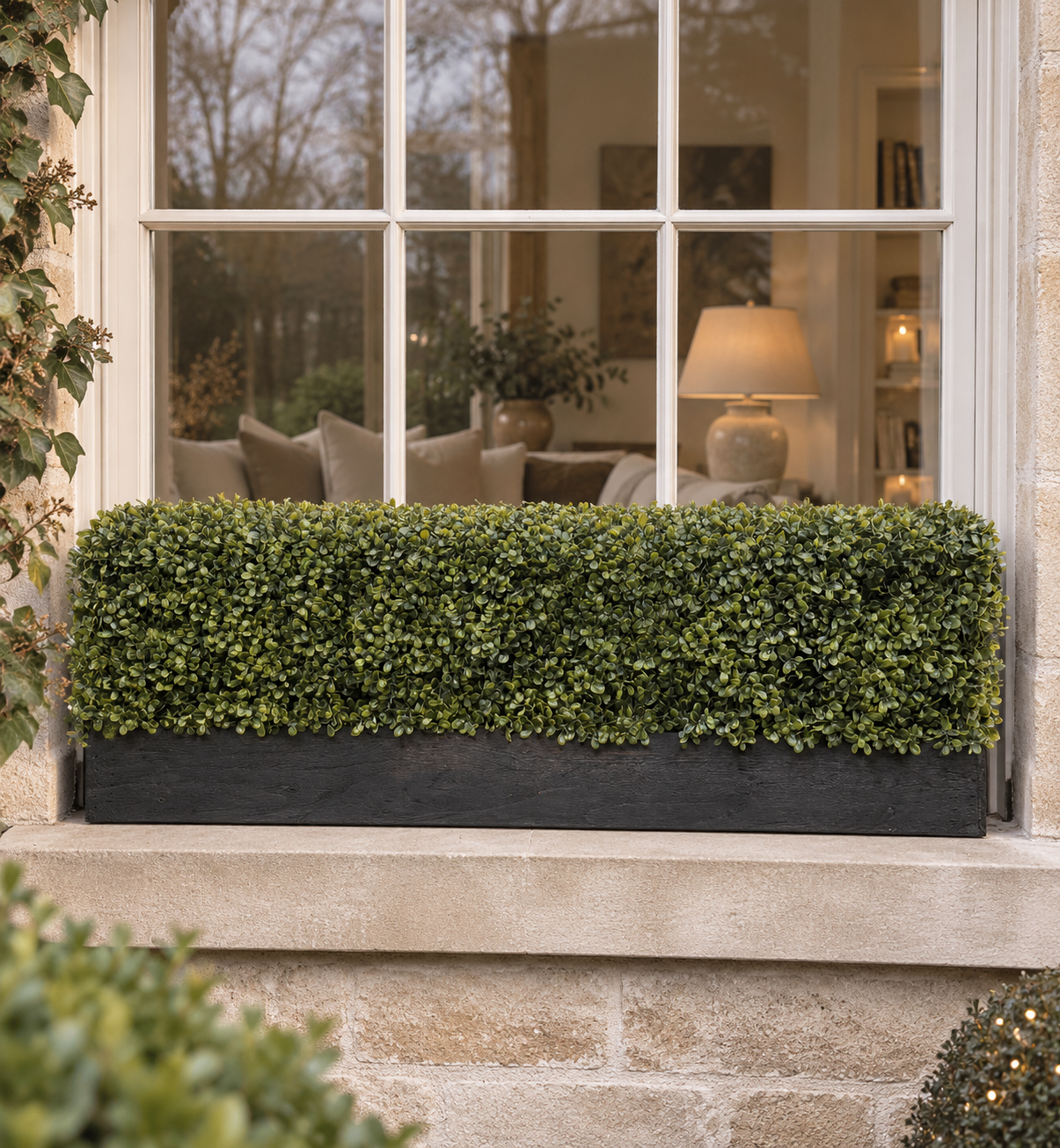 The Boxwood Ledge Window Box The Boxwood Ledge artificial window box with realistic green boxwood foliage in a black timber trough on an exterior window ledge.