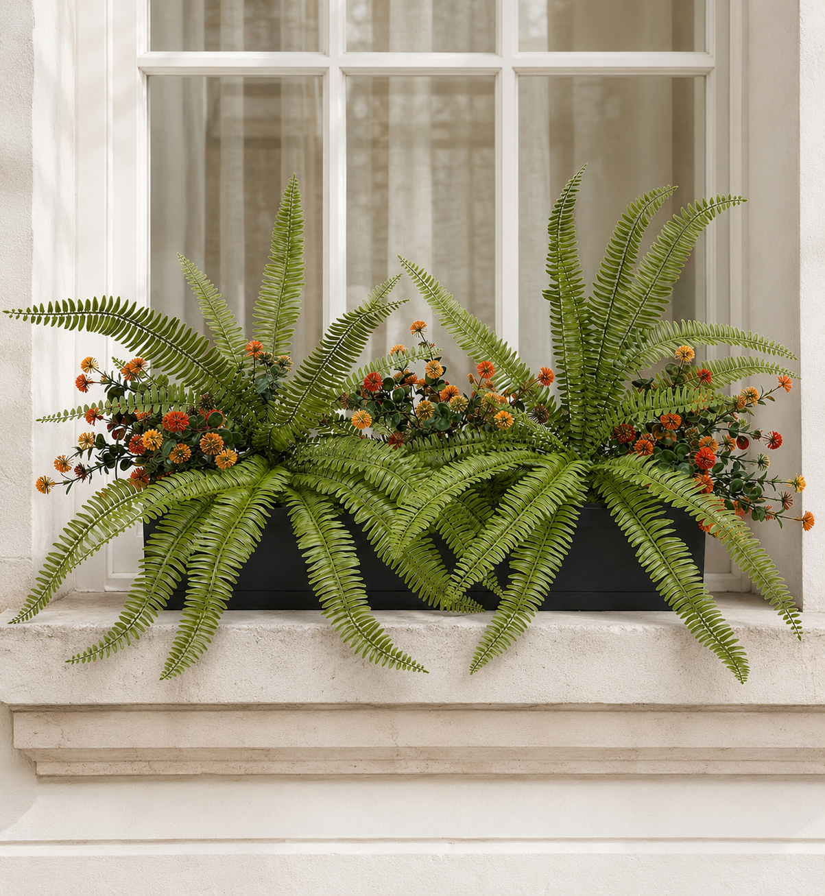 Artificial Fern & Orange Pom Pom Flower Window Box Artificial fern and orange pom pom flower window box displayed on a white stone window ledge